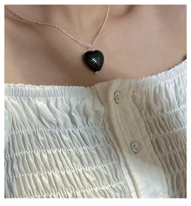 Close-up of black onyx heart pendant on an S925 sterling silver beaded chain necklace