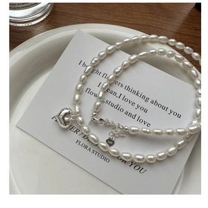Détail du fermoir mousqueton en argent S925 et du pendentif coeur sur collier perle