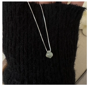 Detailed view of irregular light green gemstone pendant on silver S925 box chain