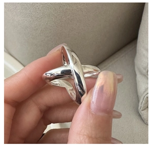 Detailed view of polished S925 sterling silver crossover ring with intertwined X design