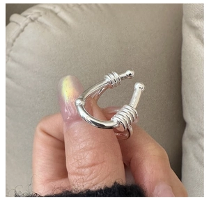 Macro detail of silver S925 U-shaped ring with horizontal textured coils and metal finish