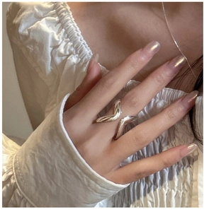 Close-up of a S925 sterling silver minimalist cross ring on a hand with glossy finish