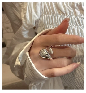 Gros plan d'une bague en argent S925 avec un design goutte fluide et une finition miroir