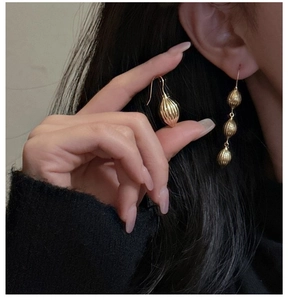 Gros plan de boucles d'oreilles coquillage en argent S925 doré avec texture striée