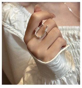 Close-up of minimalist S925 silver U-shaped open ring with beaded ends on model's hand