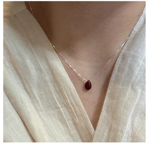 Close-up of S925 sterling silver necklace with a burgundy teardrop stone pendant