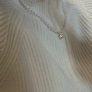 Collier élégant en argent S925 avec perles naturelles et pendentif cœur sur un pull tricoté