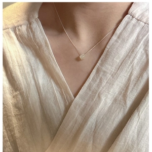 Detail of S925 silver necklace featuring a translucent natural light green stone pendant