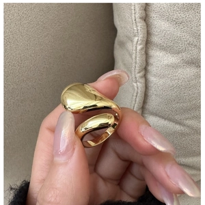 Gros plan d'une bague goutte dorée avec un design fluide de lave et une finition polie