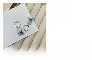 Detail view of S925 silver hoop earrings featuring irregular blue-grey natural stones