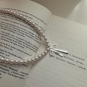 Elegant S925 sterling silver pearl necklace with a sleek metal bow pendant for women