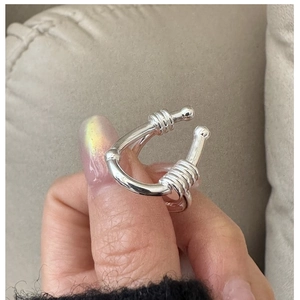 Macro shot of silver U-shaped ring featuring elegant threaded spiral details on both ends