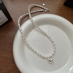 Collier en argent S925 avec pendentif cœur et perles naturelles sur une assiette blanche