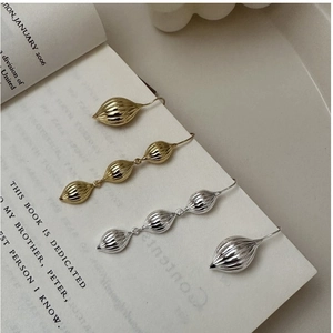 Vue détaillée de boucles d'oreilles en argent S925 à texture nervurée sur un livre