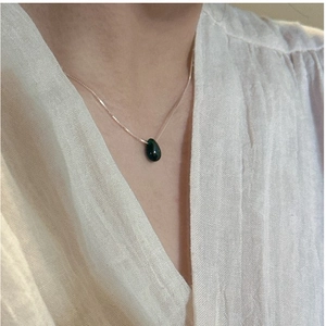 Close-up of S925 silver necklace featuring a teardrop-shaped dark green gemstone pendant