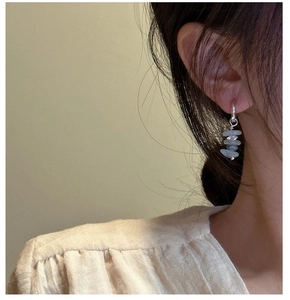 Detailed close-up of S925 silver hoop earrings with four natural grey-blue raw stone beads