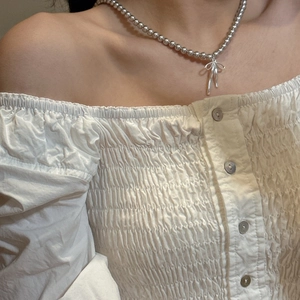 Close-up of S925 sterling silver beaded necklace with a 3D bow pendant on a model