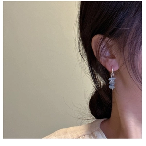 Close-up of minimalist S925 silver earrings with three light blue natural stone beads