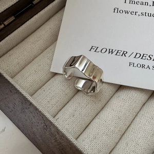 Macro shot of S925 sterling silver ring showing irregular wave texture and hallmark