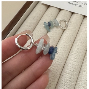 Detailed macro of S925 sterling silver hoop earrings with irregular blue raw stone beads