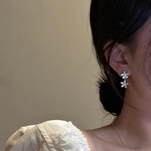 Eleganti orecchini in argento S925 a doppio fiore indossati da una modella