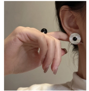 Detail of silver round stud earrings with black onyx center and concentric texture