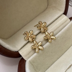 Eleganti orecchini pendenti a doppio fiore dorato in argento S925 su portagioie in velluto