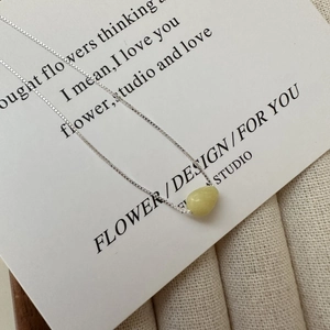S925 sterling silver necklace with a pale yellow teardrop stone pendant on a display card