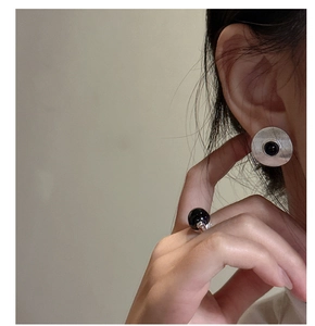 Detailed close-up of S925 silver stud earrings with black agate and spiral textures