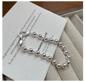 Macro view of S925 sterling silver beaded bracelet with lobster clasp and drop pendant
