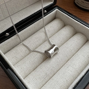 Polished silver cylinder pendant necklace elegantly displayed in a jewelry gift box