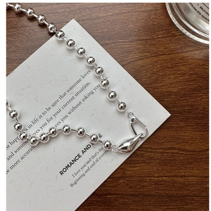 Detailed view of S925 silver beaded necklace with unique teardrop clasp on card