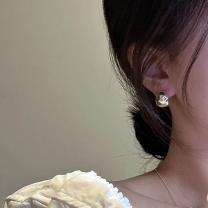 Detail of 925 sterling silver C-shaped earrings with hammered texture on model