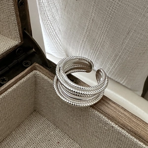 Détail de la bague en argent multicouche à texture torsadée sur une boîte à bijoux en bois