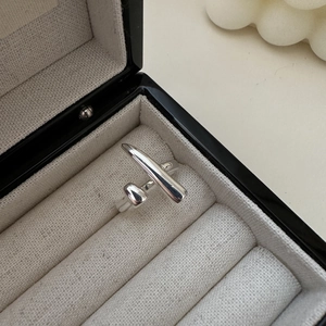 Detail shot of a minimalist s925 silver asymmetric pointed open ring on a grey jewelry cushion