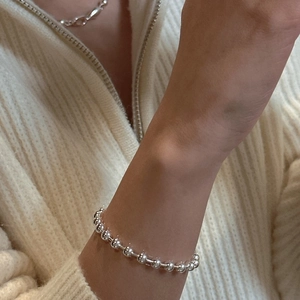 Polished S925 silver beaded bracelet on wrist featuring minimalist glossy metal spheres