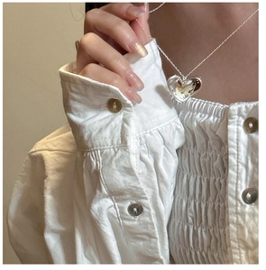 Detail view of a 925 sterling silver heart pendant necklace on a female model neck