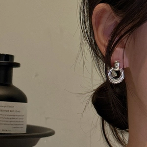 Textured S925 sterling silver hoop earrings with vintage hammered finish on a model