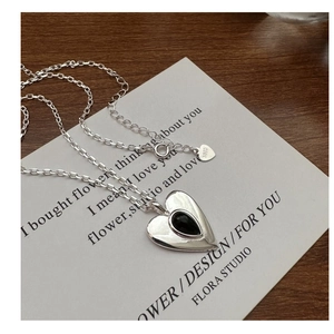 Detail of S925 sterling silver heart necklace with black onyx inlay on poetic card