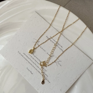 Elegant gold S925 sterling silver U-shaped pendant necklace on a textured white card