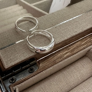 Détail de bagues minimalistes en argent sterling S925 sur un écrin à bijoux en lin