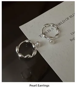 Close-up of S925 sterling silver wave hoop earrings featuring elegant white pearls