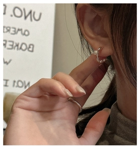 Detailed close-up of S925 silver C-shaped pearl earring worn by model in minimalist style