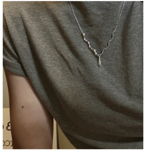 Détail macro du collier en argent S925 avec textures ondulées et pendentif goutte