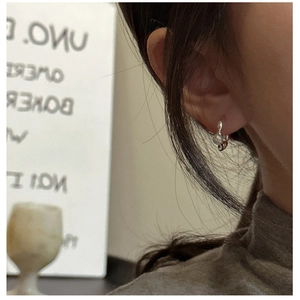 Close-up of S925 sterling silver hoop earrings with irregular liquid metal texture worn
