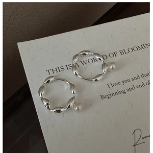 Detail of S925 silver hoop earrings with irregular texture and elegant white pearls