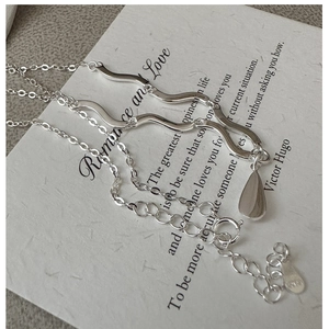 Détail macro du collier en argent S925 ondulé avec pendentif goutte et poinçon gravé