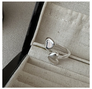 Close-up of S925 sterling silver open ring featuring a double heart design in a jewelry box