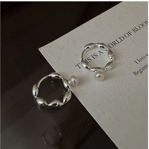 Detail of S925 silver wave-shaped hoop earrings featuring a single hanging pearl charm