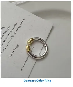 Détail macro de la bague ouverte en argent S925 avec embouts cylindriques dorés contrastés